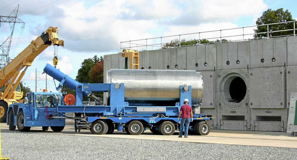 In this Oct. 14, 2010, photo released by Dominion Resources, a trailer holding a spent fuel storage container is maneuvered into position for offloading into a horizontal storage module at the Millstone Power Station in Waterford, Connecticut. With the collapse of a proposal for nuclear waste storage at Nevada’s Yucca Mountain, Millstone and other plants across the country are building or expanding on-site storage for waste.