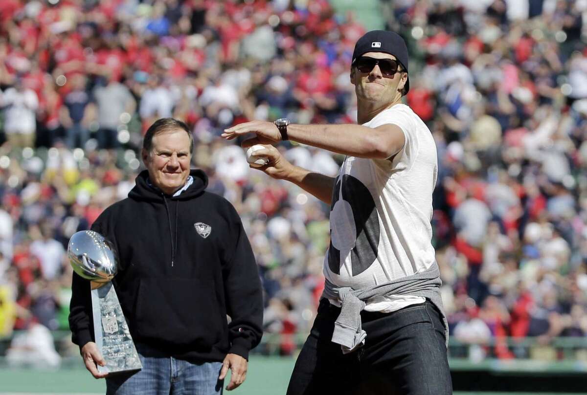 Patriots quarterback Tom Brady throws the ceremonial first pitch as Patriots head coach Bill Belichick watches prior to the Red Sox homer opener against the Washington nationals on Monday.