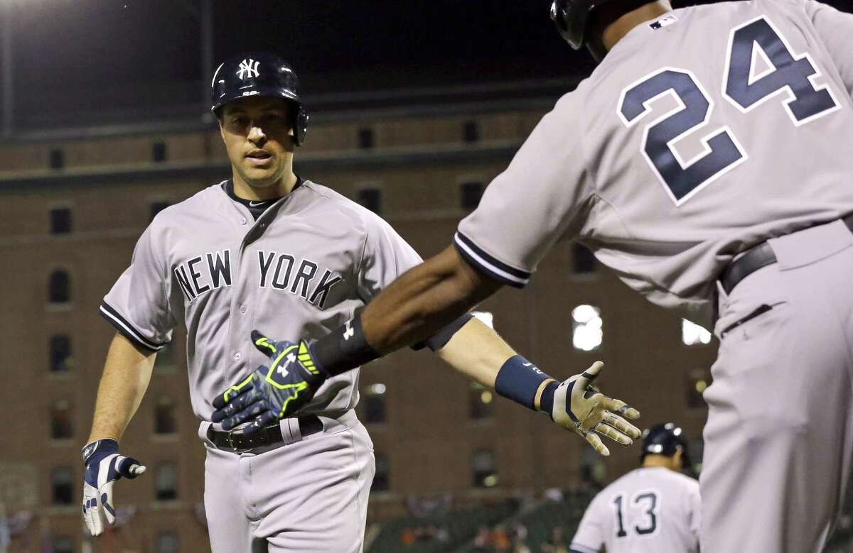 The Yankees’ Mark Teixeira, left, is greeted by teammate Chris Young after hitting a solo home run in the fourth inning on Monday.