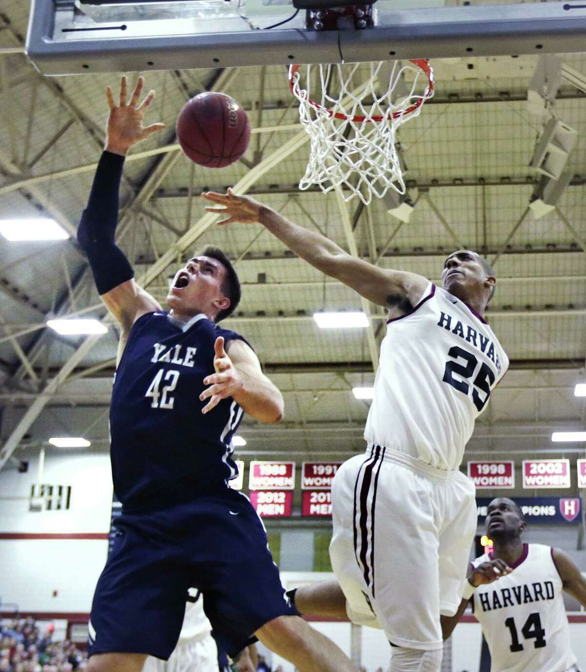 Harvard center Kenyatta Smith (25) blocks a shot by Yale’s Matt Townsend during the first half of their game on March 6.