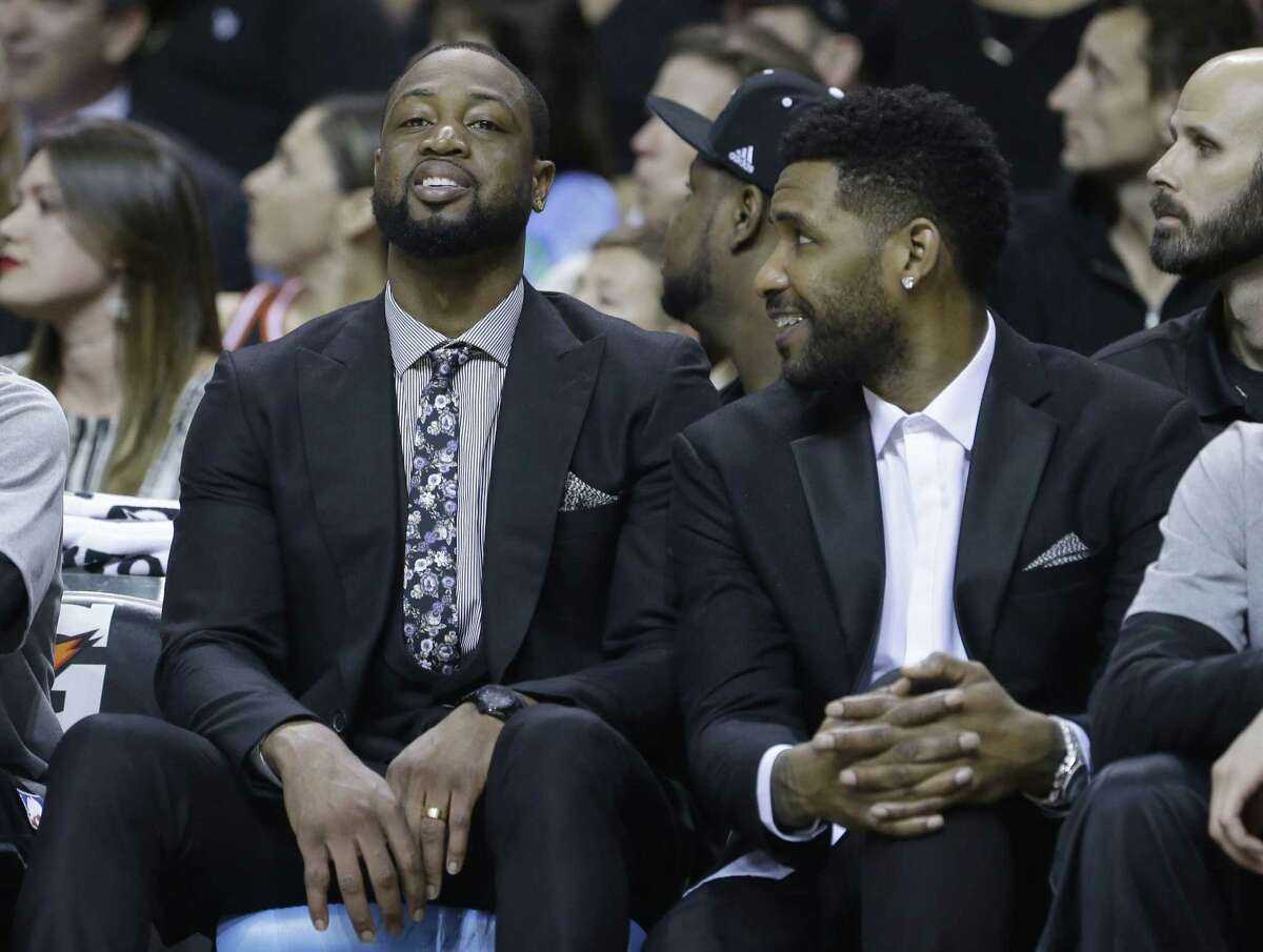 Heat guard Dwyane Wade, left, and forward Shawne Williams sit on the bench during Monday’s game against the New York Knicks in Miami.