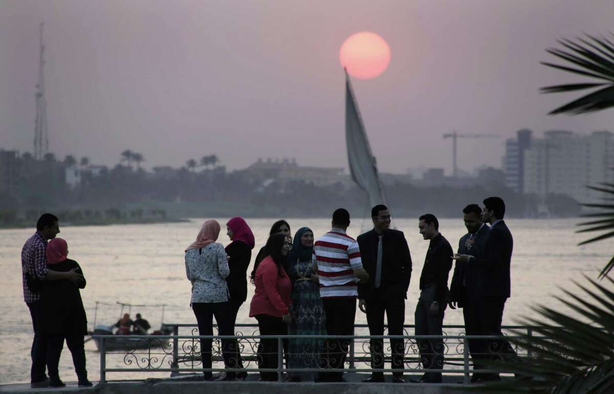 Egyptians pose for pictures as others have a small talk at sunset on the Nile River in Cairo, Egypt, Wednesday, June 3, 2015. (AP Photo/Amr Nabil)