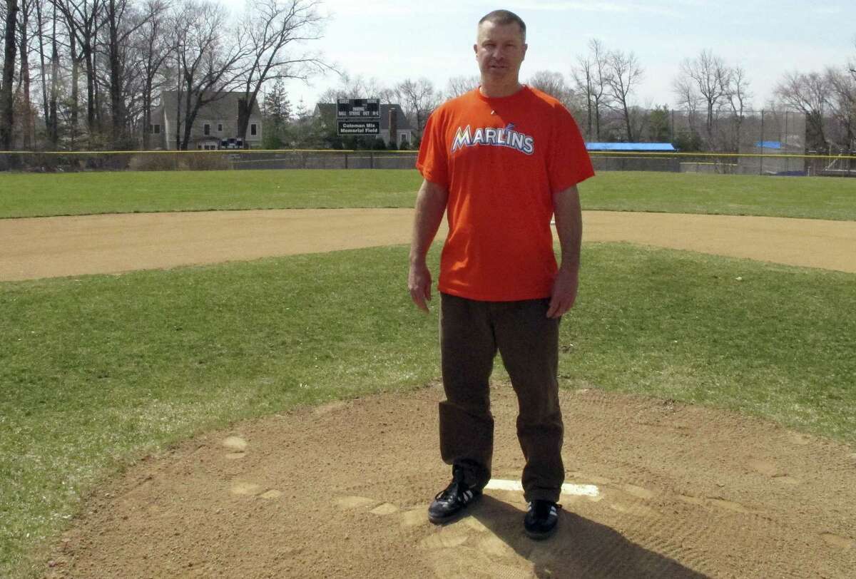 In this April 6, 2015 photo, Christopher Stefanoni poses at the Darien Little League park in Darien, Conn. Stefanoni is suing the Darien Little League in federal court, saying league officials demoted his 9-year-old son to a lower-level team as retribution for his affordable housing proposal. Lawyers for the Little League deny the allegations.