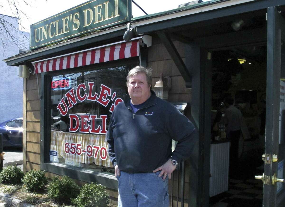 In this April 6, 2015 photo, Rob Williamson stands outside his deli in Darien, Conn. Williamson doesn’t believe the town is being discriminatory in rejecting affordable housing applications.