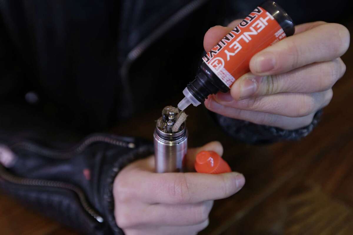 ASSOCIATED PRESS FILE PHOTO A liquid nicotine solution is poured into a vaping device.