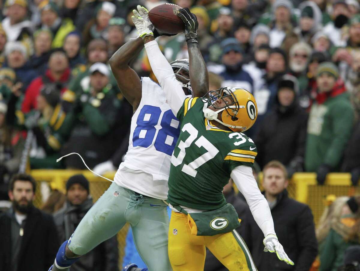 Cowboys wide receiver Dez Bryant (88) catches a pass as the Packers’ Sam Shields defends during the second half Sunday. The play was reviewed and reversed by officials.
