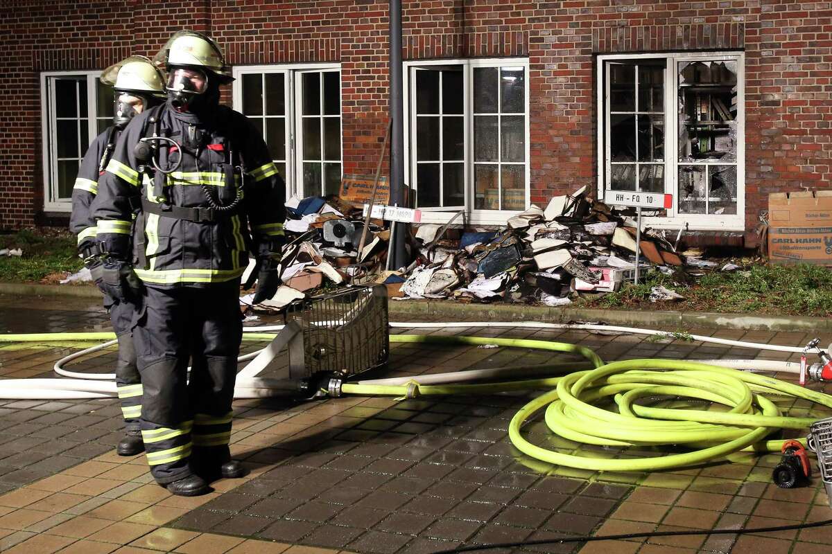 Firefighters stand outside the building of the ‘Hamburger Morgenpost’ in Hamburg, northern Germany, on Jan. 11, 2015. According to police, fire broke out in an archive room of the paper after an arson attack.