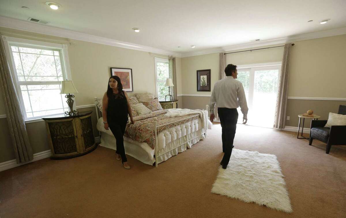 In this May 6, 2015 photo, realtor Stephan Marshall, right, walks with potential buyer Sasha Martinez at a home for sale on Perez Drive in Pacifica, Calif.