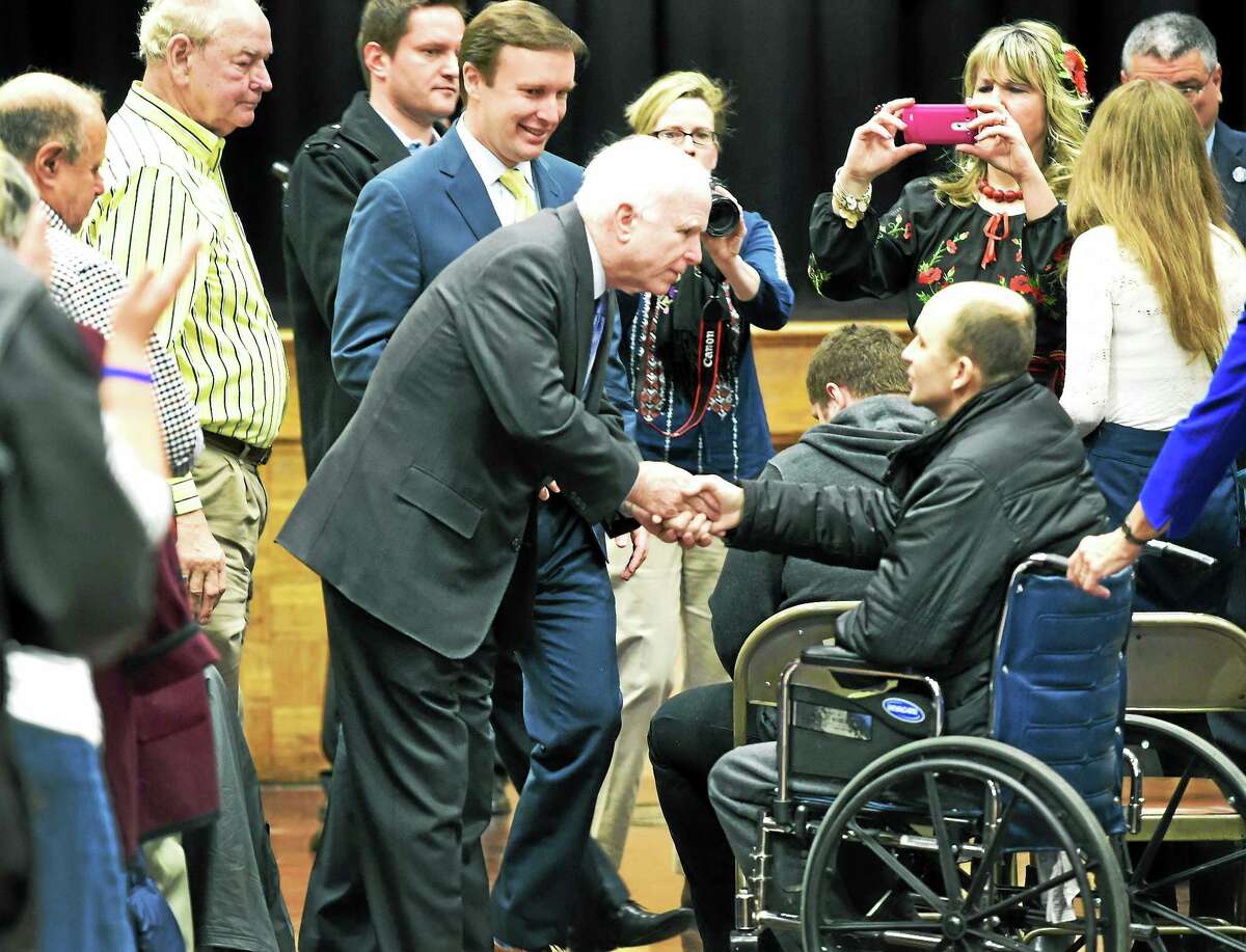 (Peter Hvizdak - New Haven Register) U.S. Sen. John McCain shakes hands with Roman Lutsiuk of Ukraine, who was wounded in the fighting against pro-Russian insurgents in Ukraine near the Polish border. Lutsiuk met with McCain and U.S. Sen. Christopher Murphy and the local Ukrainian community at the Ukrainian National Home in Hartford, Monday, March 9, 2015. Lutsiuk is being treated at Yale-New Haven Hospital for injuries suffered in the Ukrainian conflict. The senators held a discussion with the community on the ongoing crisis and the United States’ role in supporting the Ukrainian people.