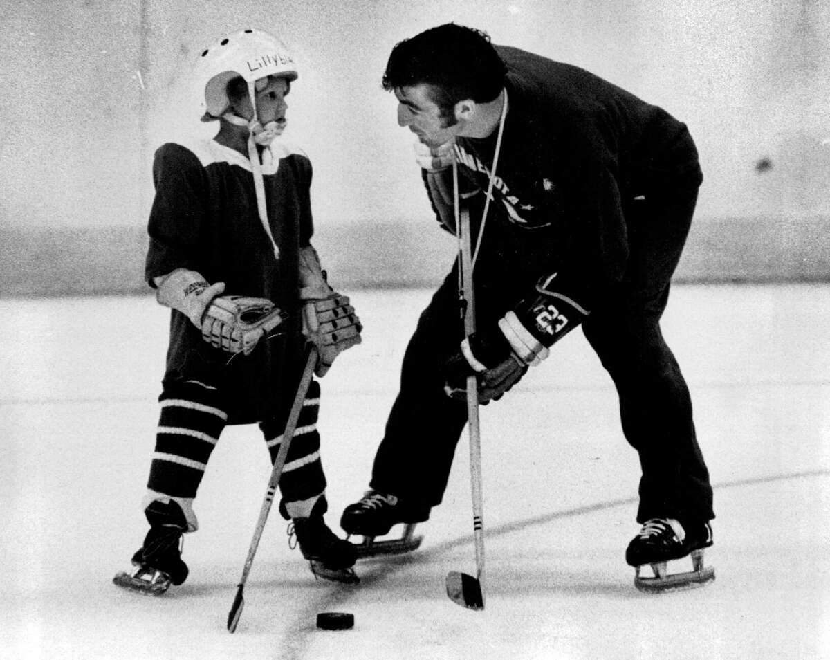 In this June 24, 1971 photo, J.P. Parise gives advise to 5-year-old Mike Lillyblad at the Minnesota North Stars hockey clinic in Bloomington, Minn. Parise died from lung cancer on Wednesday night at the age of 73.