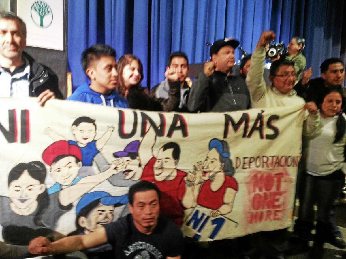 Activists unfurl banner at forum on immigration and Obama’s executive actions. Ni Una Mas refers to not one more deportation.