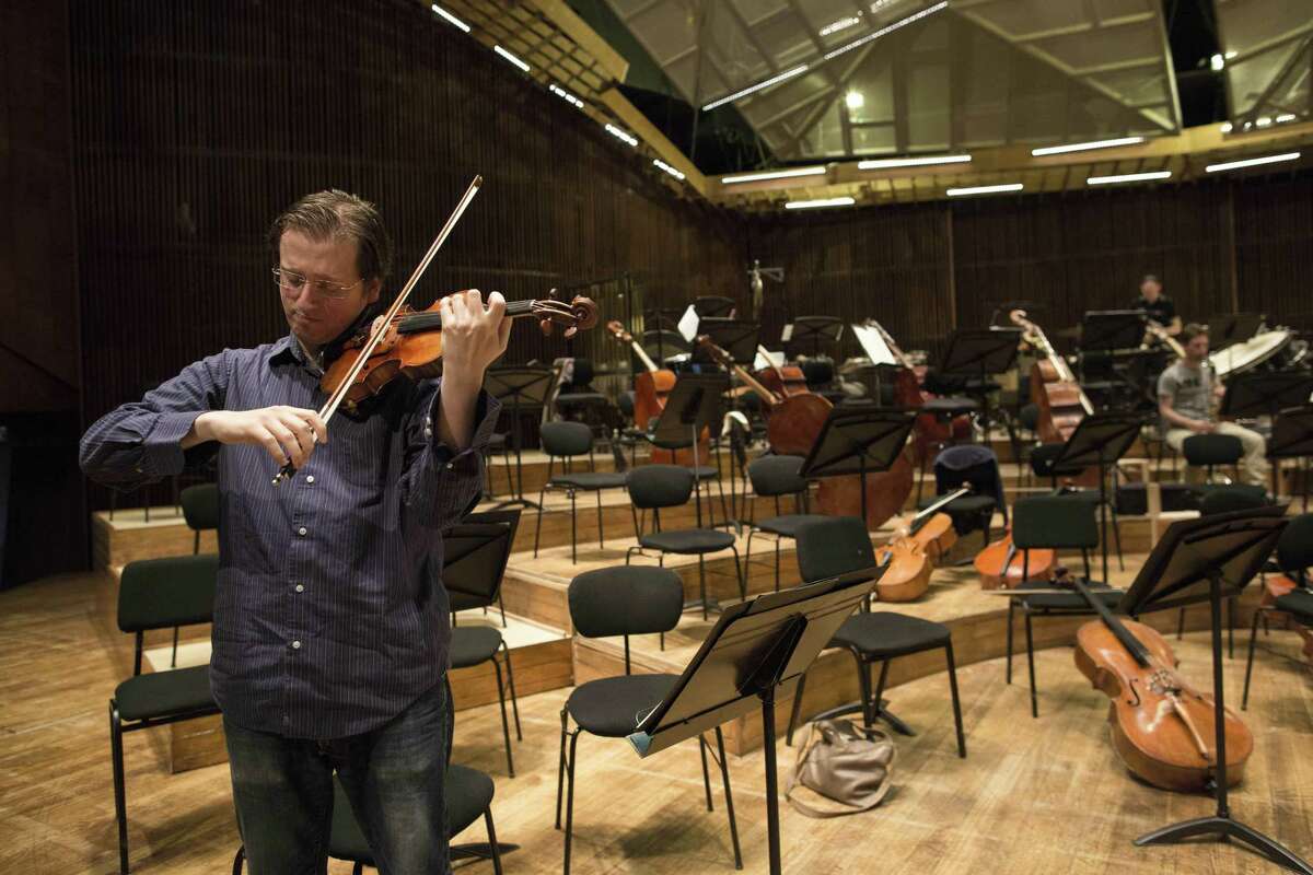 In this May 3, 2015 photo, David Radzynski an American-Israeli concertmaster of the Israel Philharmonic Orchestra, plays during a rehearsal in Tel Aviv concert hall. Radzynski is still getting used to his first job out of college as the new concertmaster of the Israel Philharmonic Orchestra - and to being one of the youngest violinists to lead a major world orchestra today.