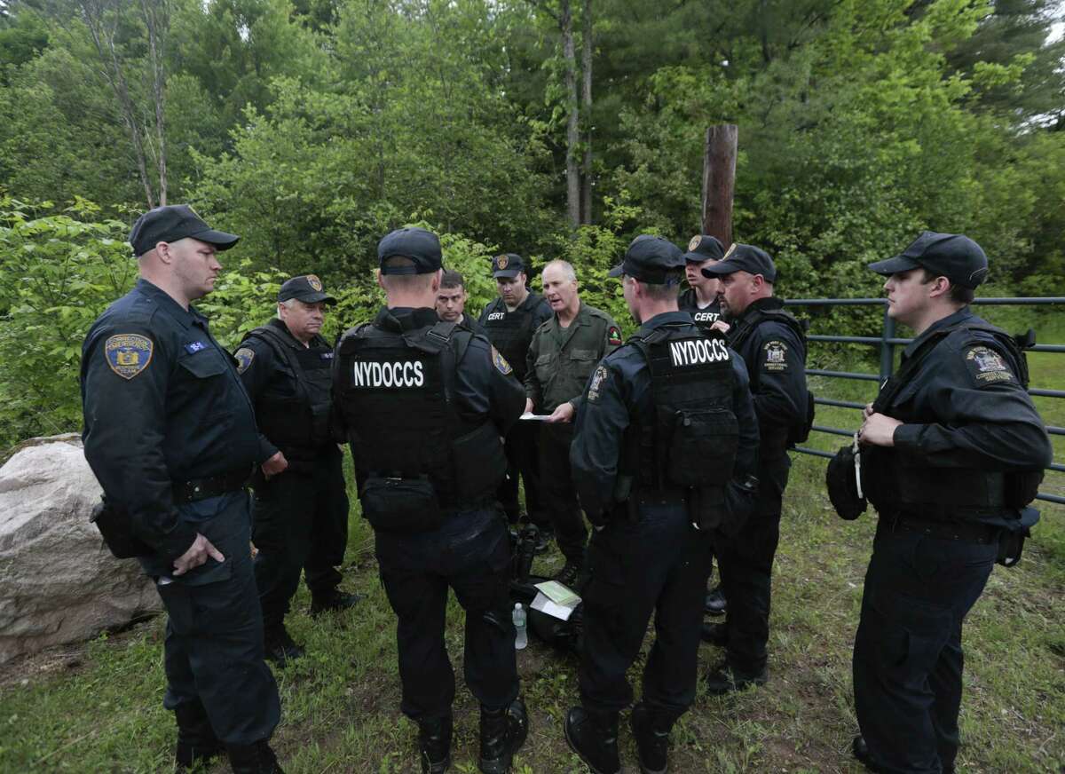 State forest ranger Dan Fox reviews a map with members of the New York State Department of Corrections and Community Supervision emergency response team before entering a wooded area in search of two prisoners who escaped from the Clinton Correctional Facility on Monday, June 8, 2015, in Dannemora, N.Y. The two murderers who escaped from the prison by cutting through steel walls and pipes remain on the loose Monday as authorities investigate how the inmates obtained the power tools used in the breakout.