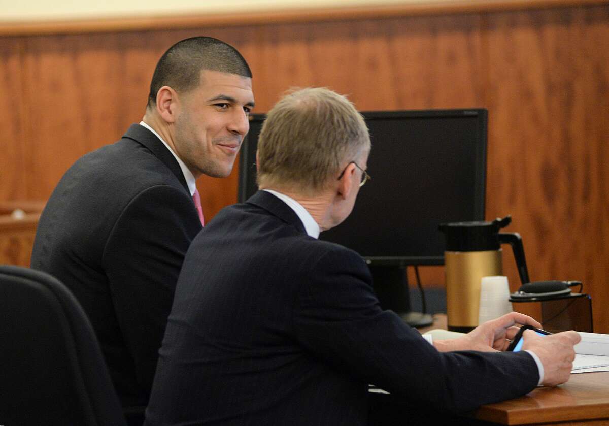 Aaron Hernandez smiles with defense attorney Charles Rankin in the courtroom of the Bristol County Superior Court House on Wednesday in Fall River, Mass.