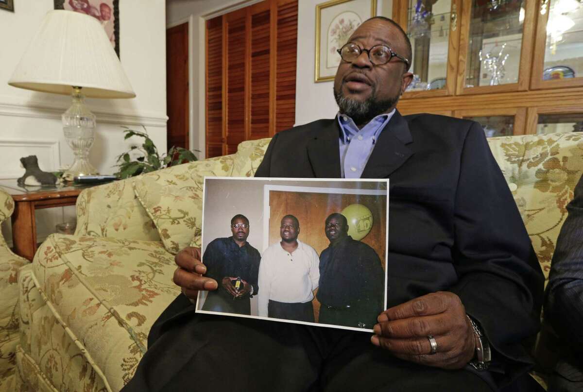 Anthony Scott holds a photo of himself, center, and his brothers Walter Scott, left, and Rodney Scott, right, as he talks about his brother at his home near North Charleston, S.C. on April 8, 2015.