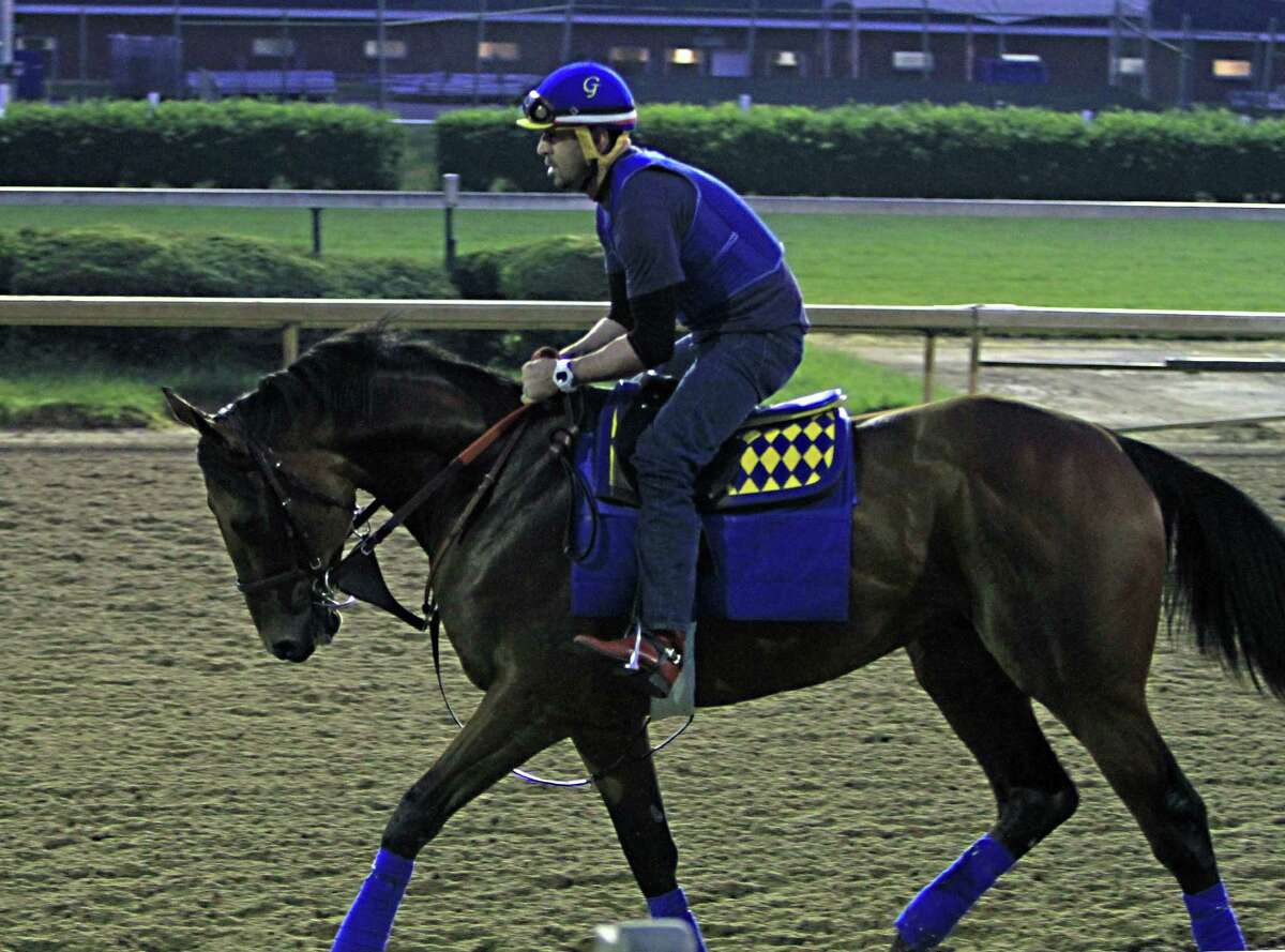 Exercise rider Jorge Alvarez jogs Kentucky Derby winner American Pharoah the wrong way around the track on Thursday at Churchill Downs in Louisville, Ky.
