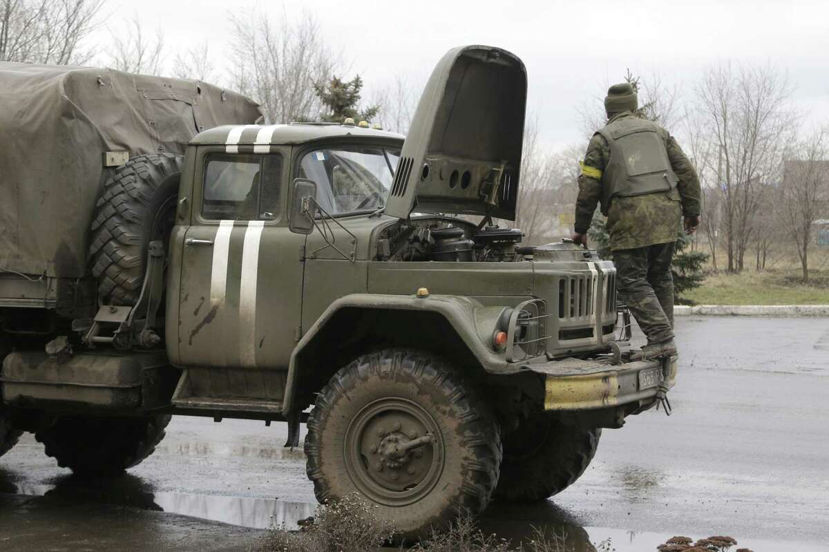 Ukranian government soldiers tries to fix his truck in Artemivsk, Ukraine, Wednesday, Feb. 4, 2015. Soldiers bark orders at exhausted residents boarding evacuation buses with overflowing bags in hand, as another rebel artillery attack pummels this town on the front lines of Ukraineís separatist war. Despair is deepening for a shrinking population that has been without power, heating and running water for almost two weeks. The relentless rebel advance on the railway town of Debaltseve is being slowed only by Ukrainian tanks, cannons and rocket launchers. (AP Photo/Petr David Josek)