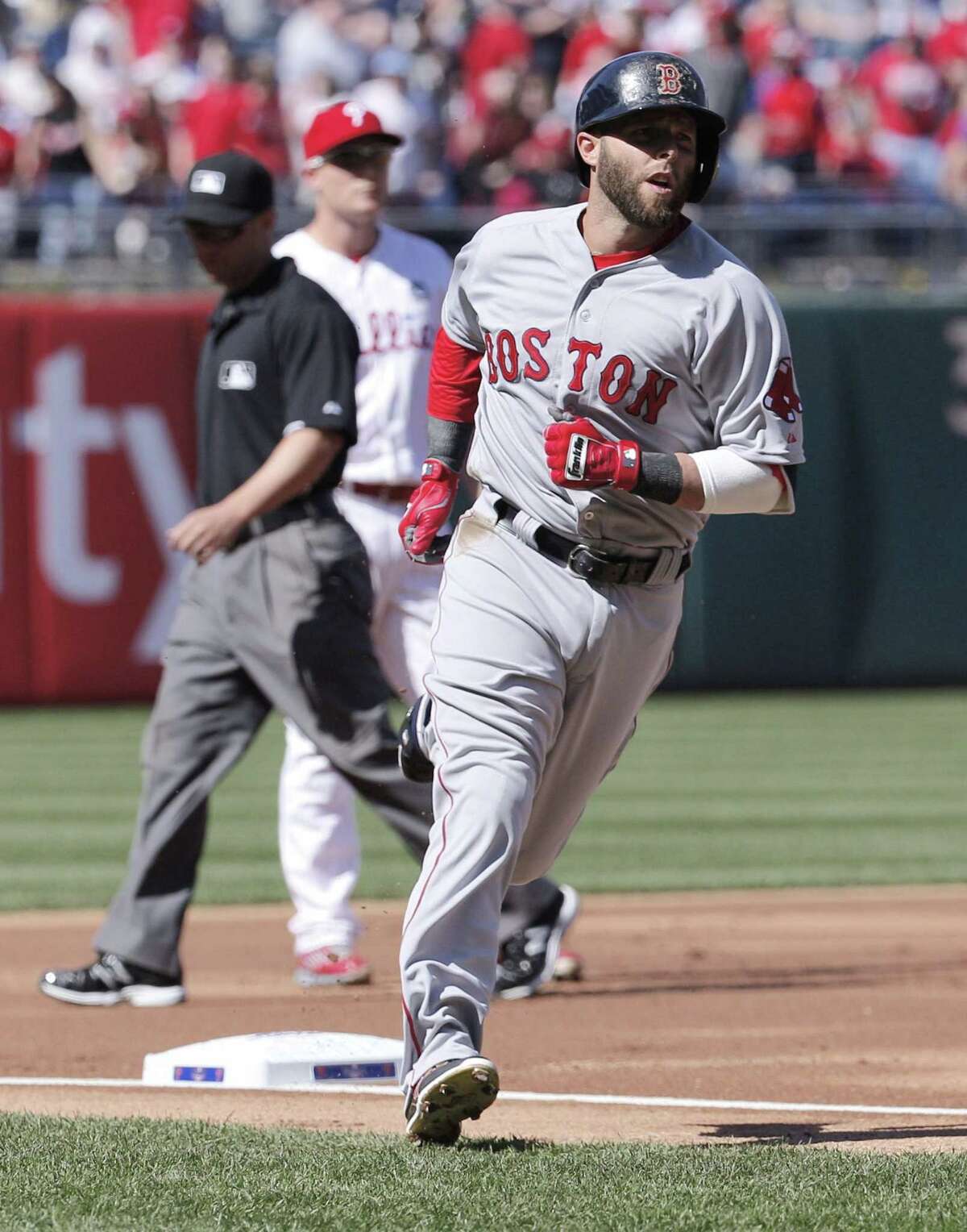 Boston Red Sox Dustin Pedroia rounds third base after hitting a solo home run during the first inning.