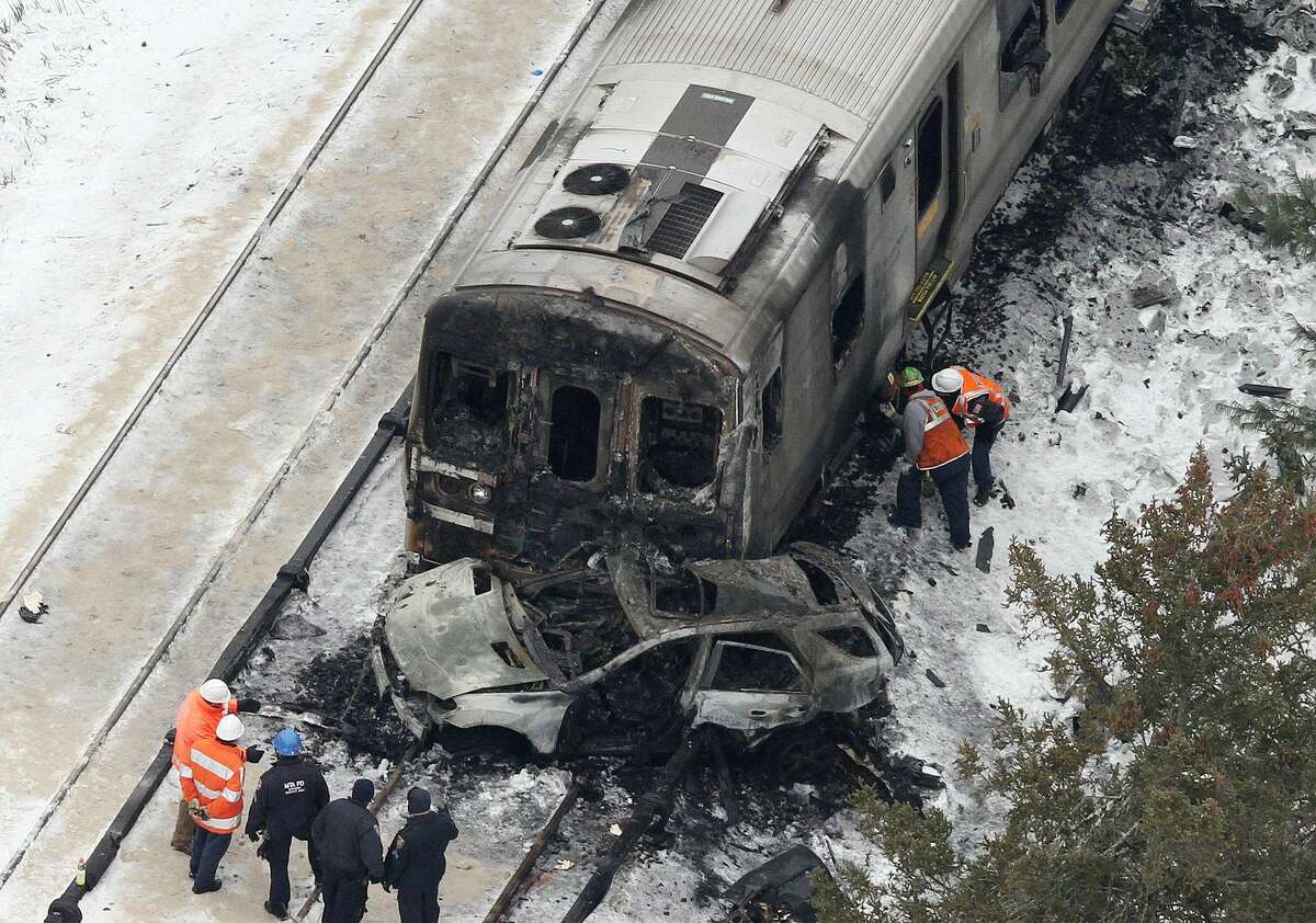 The burned out shell of an SUV, rests against a charred Metro-North Railroad commuter train as personnel from various agencies work the scene of a deadly accident in Valhalla, N.Y., Wednesday, Feb. 4, 2015. (Frank Becerra Jr. — The Journal-News)