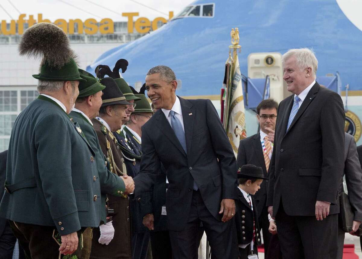 U.S. President Barack Obama, joined by Horst Seehofer, Minister President of Bavaria, right, is greeted by traditionally dressed Bavarian men and women as he arrives on Air Force One at the airport in Munich, Germany on June 7, 2015, en route to the G-7 summit at the Schloss Elmau hotel near Garmisch-Partenkirchen, southern Germany.