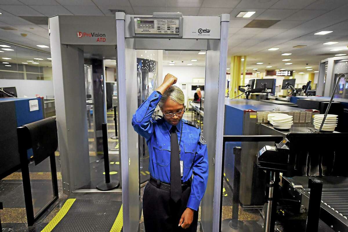 Barbara Toyer, a TSA supervisor, calibrates a walk-through metal detector for use at a security checkpoint at Ronald Reagan Washington National Airport on Dec. 22, 2014.