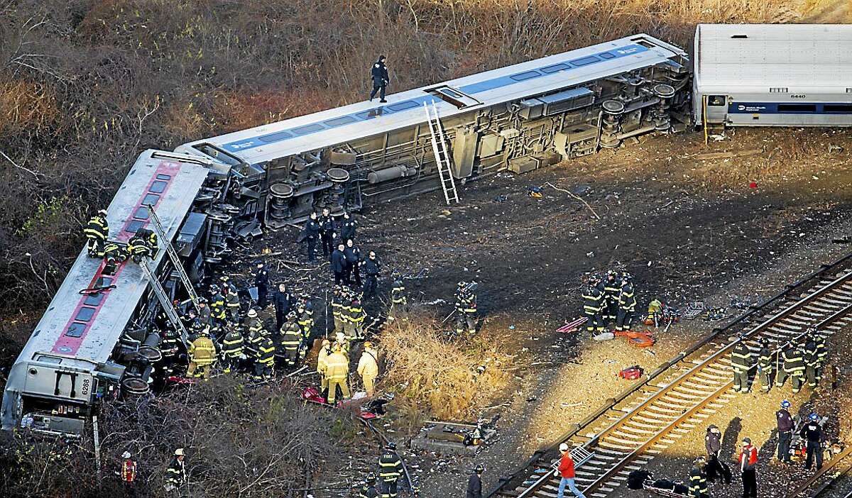 FILE - In this Sunday, Dec. 1, 2013, file photo, first responders work the scene of a derailment of a Metro-North passenger train in the Bronx borough of New York.