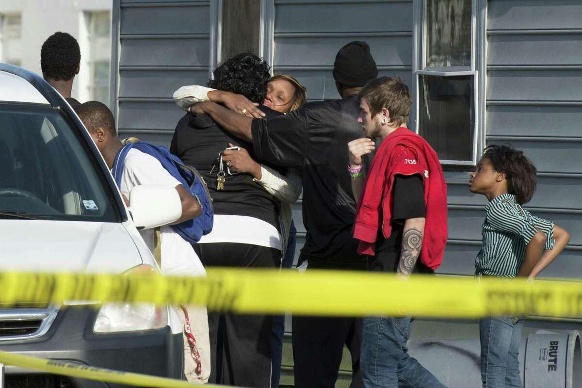 Onlookers gather outside of a house, where police say seven children and one adult have been found dead Monday in Princess Anne, Md.