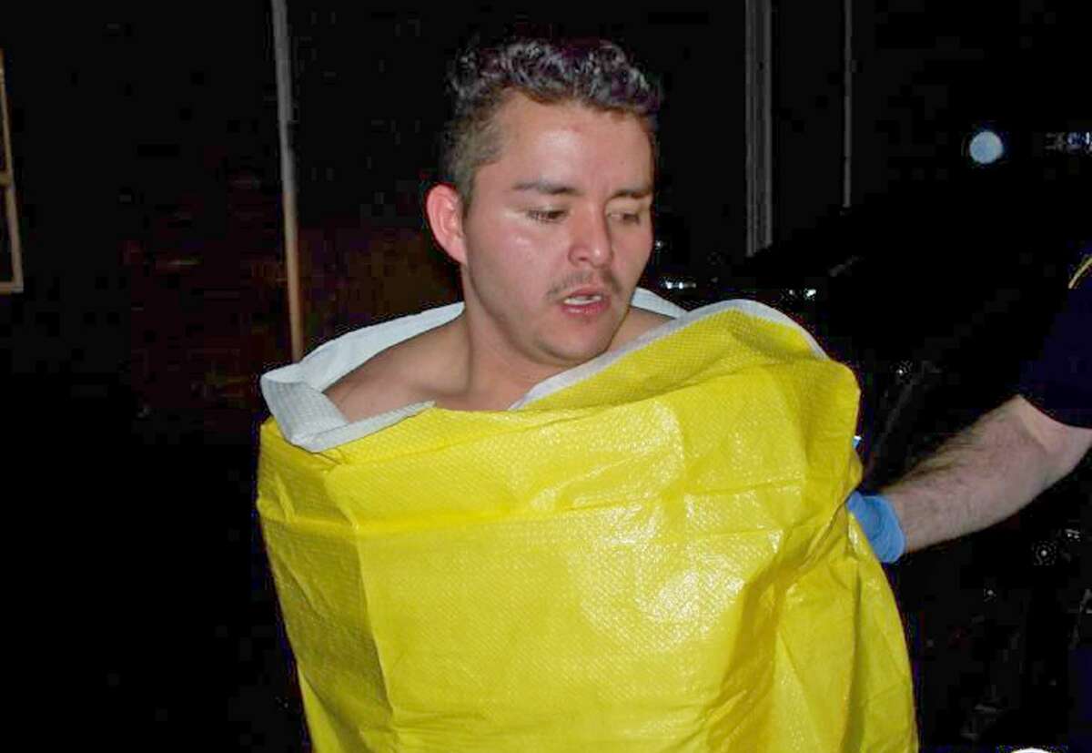 In this photo released by the Keizer, Ore., Police Department, 24-year-old Guillermo Brambila Lopez, of Woodburn, Ore., is wrapped in a blanket following his arrest Sunday.