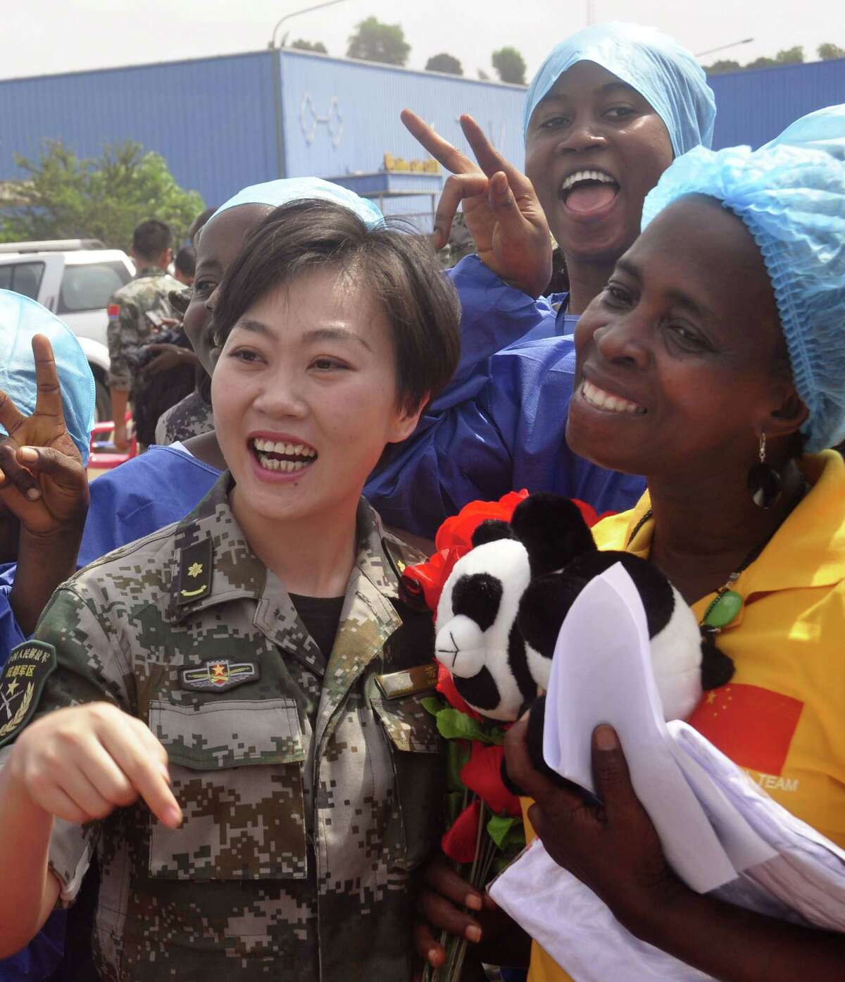 Ebola patient Beatrice Yardolo, right, celebrate with a Chinese military health workers and others as she leaves the Chinese Ebola treatment center were she was treated for the Ebola virus infection outskirts of Monrovia, Liberia, Thursday, March 5, 2015. Liberia released its last Ebola patient, a 58-year old English teacher, from a treatment center in the capital on Thursday, beginning its countdown to being declared Ebola free. 'I am one of the happiest human beings today on earth because it was not easy going through this situation and coming out alive,' Beatrice Yardolo told The Associated Press after her release. She kept thanking God and the health workers at the center.(AP Photo/ Abbas Dulleh)