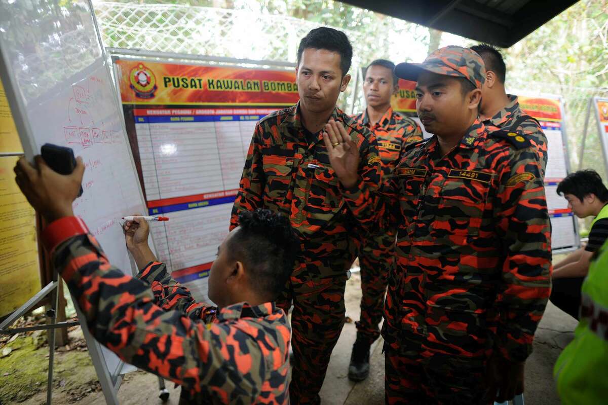 Members of the Malaysian rescue team plan as they wait for victims to be evacuated a day after an earthquake in Kundasang, a town in the district of Ranau, Malaysia, on Saturday, June 6, 2015. A Malaysian official says the bodies of nine more climbers have been recovered from the country’s highest peak a day after it was struck by a strong earthquake, bringing the total dead to 11.