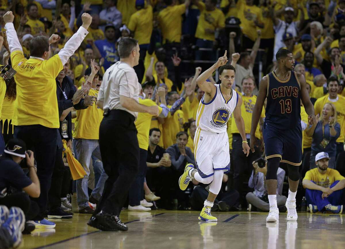 Warriors guard Stephen Curry, center, reacts after scoring in front of Cavaliers center Tristan Thompson during the first half of Game 1 of the NBA Finals on Thursday.