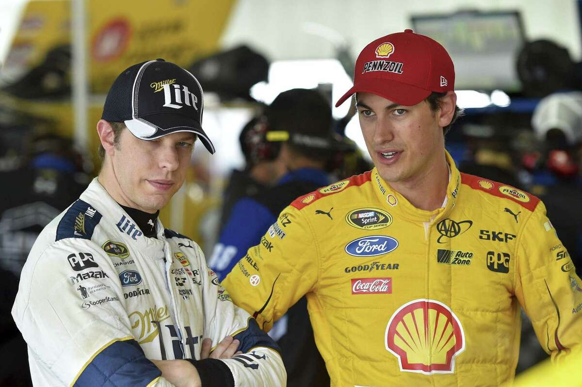 Brad Keselowski, left, stands with Joey Logano in the garage area at Pocono Raceway Friday in Long Pond, Pa.