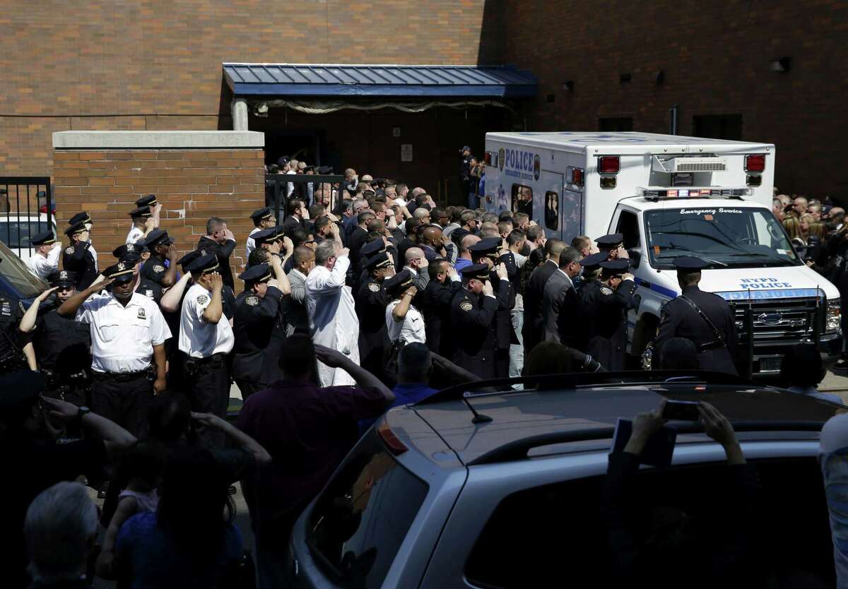 Police officers salute as the body of Brian Moore leaves Jamaica Hospital in New York, Monday, May 4, 2015. A 25-year-old police officer shot in the head over the weekend while attempting to stop a man suspected of carrying a handgun has died from his injuries, the third New York Police Department officer slain in the line-of-duty in five months, a City Hall official said Monday. (AP Photo/Seth Wenig)