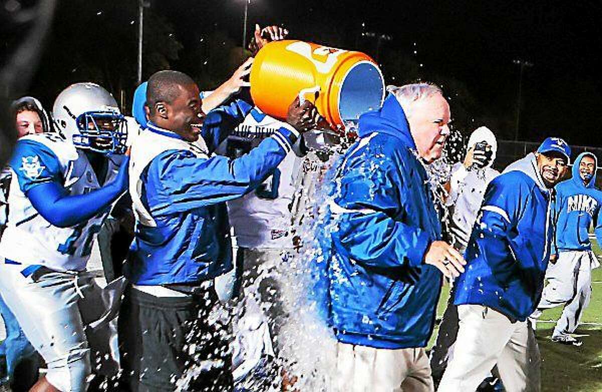 West Haven football coach Ed McCarthy gets an ice bath from his teamís players after defeating Hamden 49-7 in celebration of McCarthyís 322 career win, setting the all-time record in 2013.