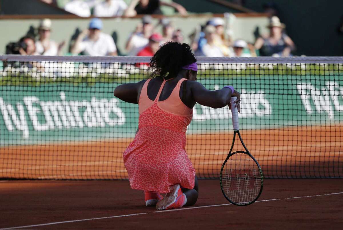 Serena Williams kneels at the net as she plays Timea Bacsinszky during their semifinal match at the French Open on Thursday at the Roland Garros stadium in Paris.