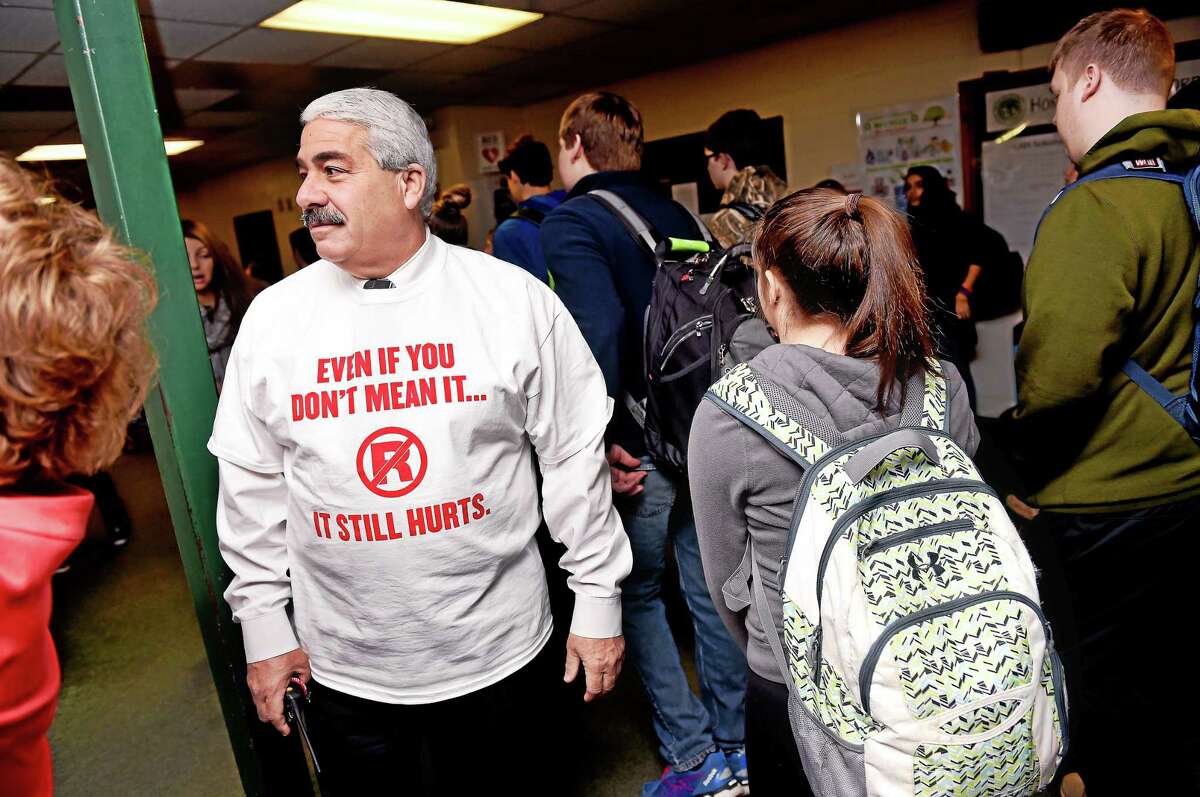 Guilford High School Principal Richard Misenti, left, watches students go to class after the “Spread the Word to End the Word” campaign event Tuesday.