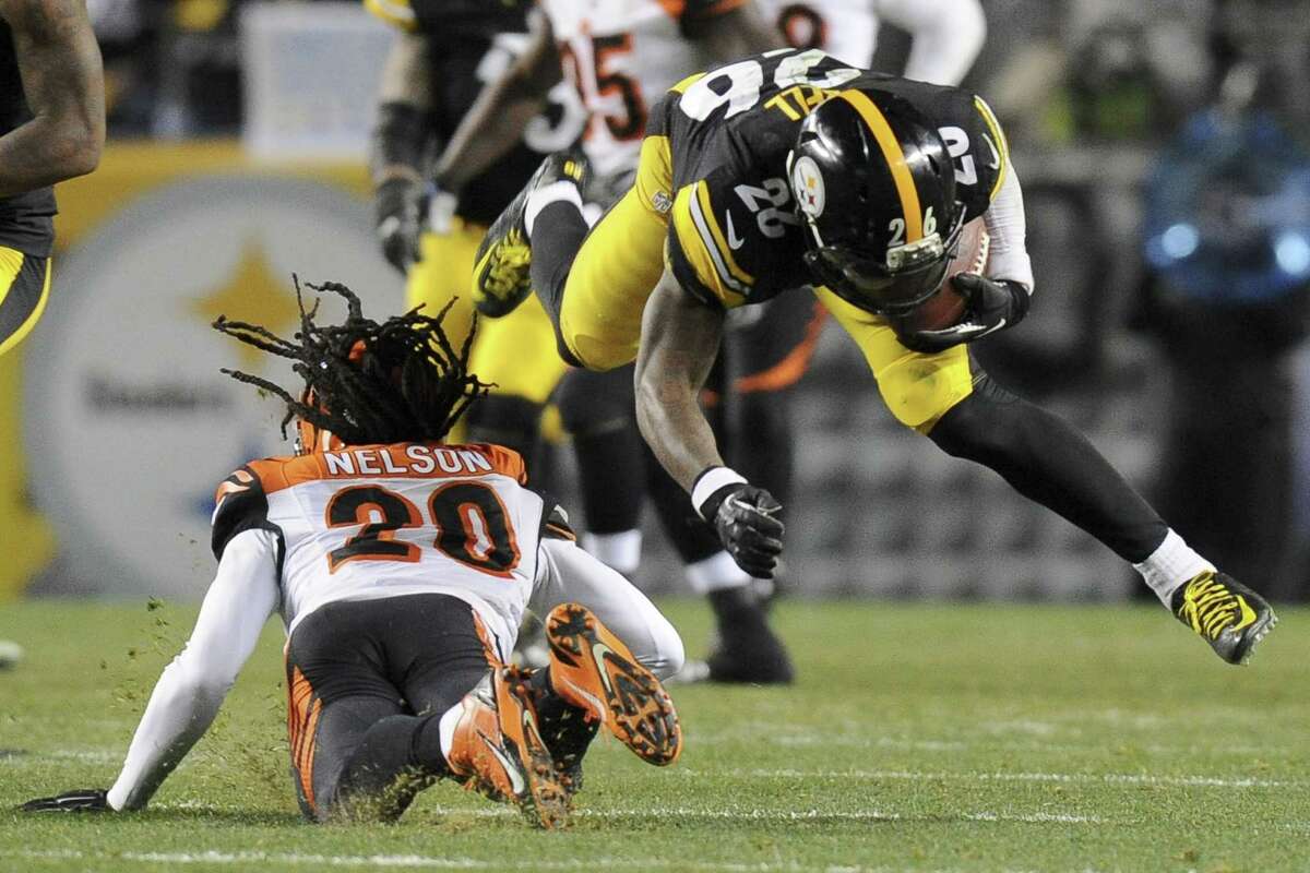 Steelers running back Le’Veon Bell is hit by Cincinnati Bengals free safety Reggie Nelson during Sunday’s game in Pittsburgh. Bell was injured on the play.