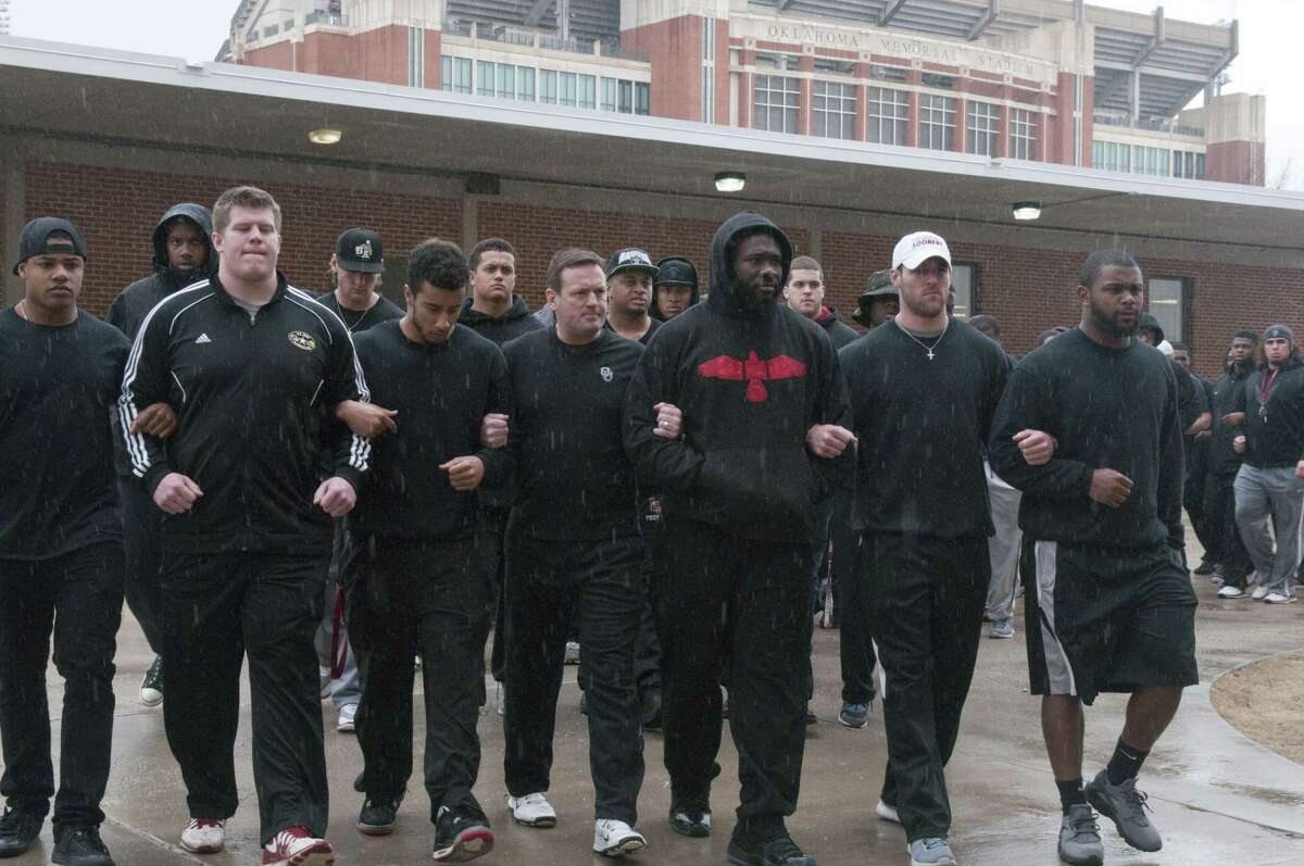 The University of Oklahoma football team and coaches line up wearing all black in the Everest Training Center in protest of the Sigma Alpha Epsilon fraternity at the University of Oklahoma on March.