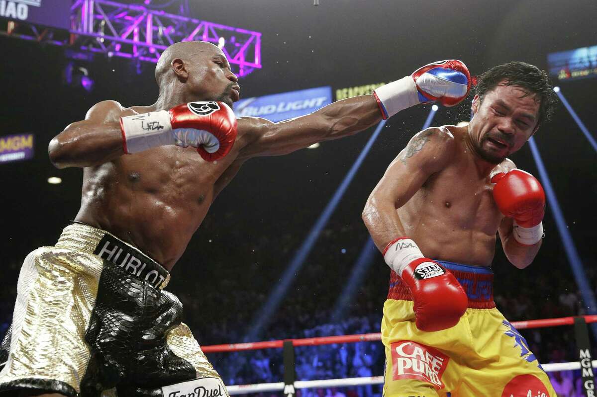 Floyd Mayweather Jr., left, hits Manny Pacquiao during their welterweight title fight in Las Vegas Saturday.