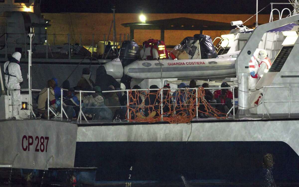 Migrants arrive at the Lampedusa island harbor aboard an Italian Coast Guard ship early Sunday, May 3, 2015. Ships rescued 3,690 migrants in just one day from smugglers’ boats on the Mediterranean Sea off the Libyan coast, the Italian Coast Guard said.