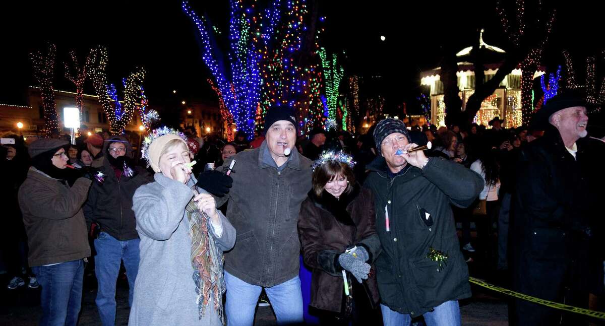 In this Dec. 31, 2013 photo, people cheer and celebrate New Year's Eve during the annual Boot Drop on Whiskey Row in downtown Prescott, Ariz. Televised images every year of New York Cityís glittery ball drop in Times Square have become inextricably linked with New Yearís Eve. But Times Square isnít the only place to ring in the new year with an object dropping from the sky at midnight. (AP Photo/The Daily Courier, Les Stukenberg)
