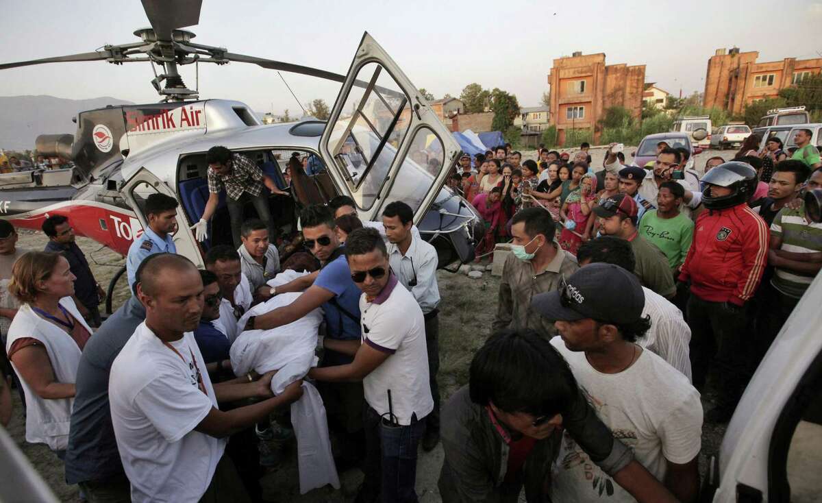 Rescuers carry the body of a victim of a helicopter crash as it arrives at the Teaching hospital after being airlifted by a chopper in Kathmandu, Nepal, Tuesday, June 2, 2015. A helicopter returning to Kathmandu crashed in the mountains in northeast Nepal on Tuesday. (AP Photo/Niranjan Shrestha)