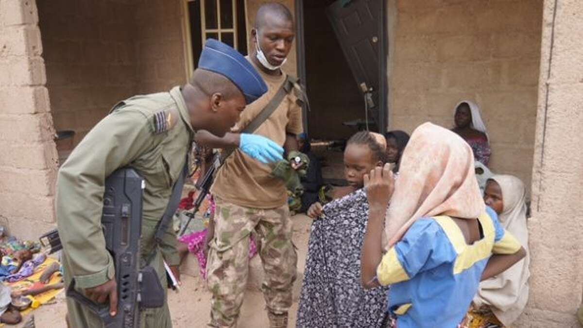 In this photo made available by the Nigerian Military taken Wednesday, April 29, 2015, a Nigerian soldier speaks to woman and children that were allegedly rescued by the Nigerian Military after being taken by Islamic extremists in Sambisa Forest, Nigeria. Scores more women and children have been rescued from Islamic extremists in the remote Sambisa Forest, Nigeria’s military said amid reports that some of the women fought their rescuers fiercely.