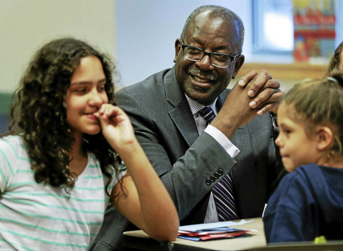 Kevin Washington, center, president and CEO of the YMCA of the USA, participates in a math game being played by young teens at the McBurney YMCA during an open after-school program called The Zone, Wednesday, April 22, 2015, in New York. Washington was installed as president and CEO in February and oversees 900 locally run associations which operate a total of 2,700 branches serving about 9 million youth and 13 million adults in communities ranging from affluent suburbs to hard-up inner-city districts.