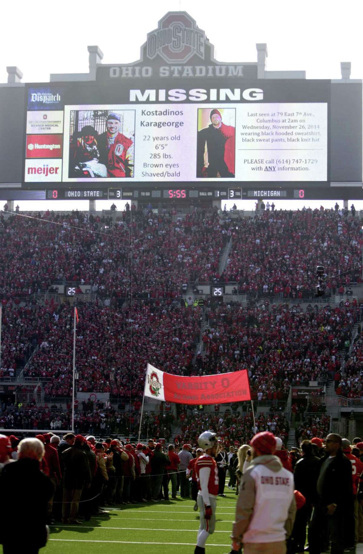 FILE - In this Nov. 29, 2014, file photo, a police poster showing Kosta Karageorge, an Ohio State player who has been missing since earlier in the week, is displayed on the large video board at the south end of the field before the Ohio State NCAA college football game against Michigan in Columbus, Ohio. Police tell media outlets Sunday, Nov. 30, 2014, they believe a body found near the campus was that of 22-year-old Karageorge.