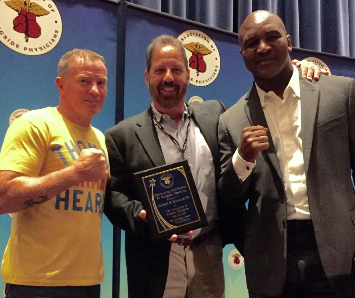 Dr. Michael Schwartz, center flanked by Evander Holyfield, right and Micky Ward at at the Association of Ringside Physician gala at Mohegan Sun Casino on July 22. Schwartz was honored for his contributions to ringside medicine.