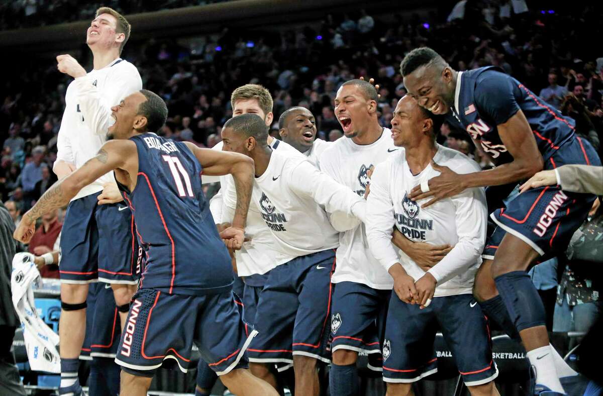 Connecticut's Ryan Boatright (11) and Amida Brimah (35) celebrate with teammates during the second half of a regional final against Michigan State in the NCAA college basketball tournament, Sunday, March 30, 2014, in New York. Connecticut won 60-54. (AP Photo/Frank Franklin II)