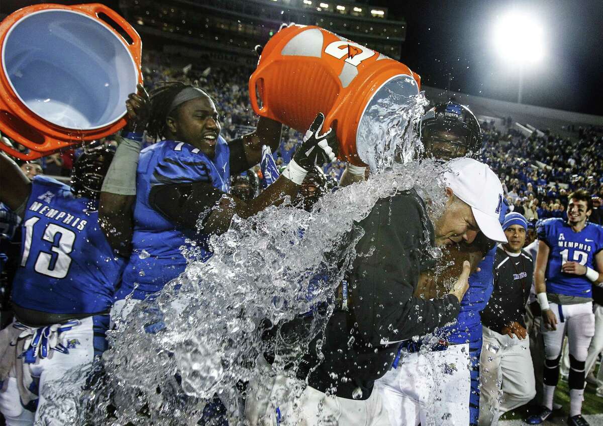 Memphis head coach Justin Fuente, right, is doused with water after the Tigers beat UConn 41-10 Saturday to clinch a share of the AAC title.