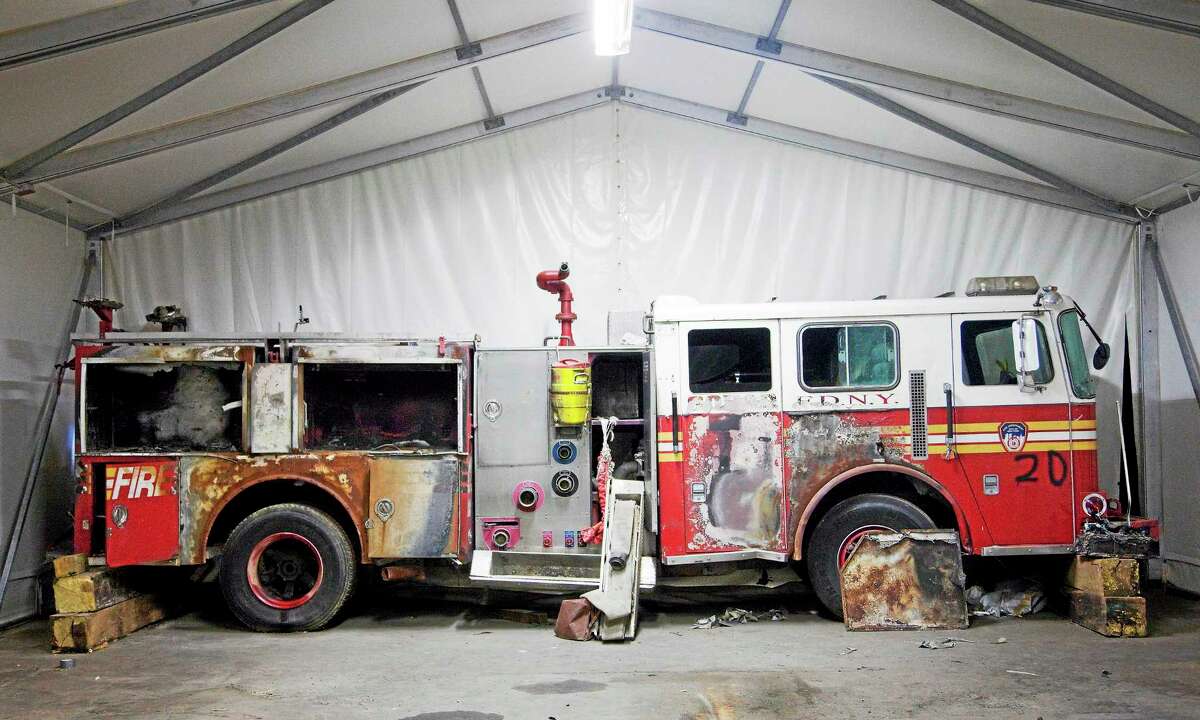 FILE - In this file photo of June 19, 2011, a damaged New York Fire Department truck is stored in Hangar 17 at John F. Kennedy International Airport in New York. The truck is part of the collection of artifacts for the National September 11 Museum. The long-awaited museum dedicated to the victims of the Sept. 11 terror attacks will open to the public at the World Trade Center site on May 21, officials announced Monday, March 24, 2014. (AP Photo/Mark Lennihan, File)