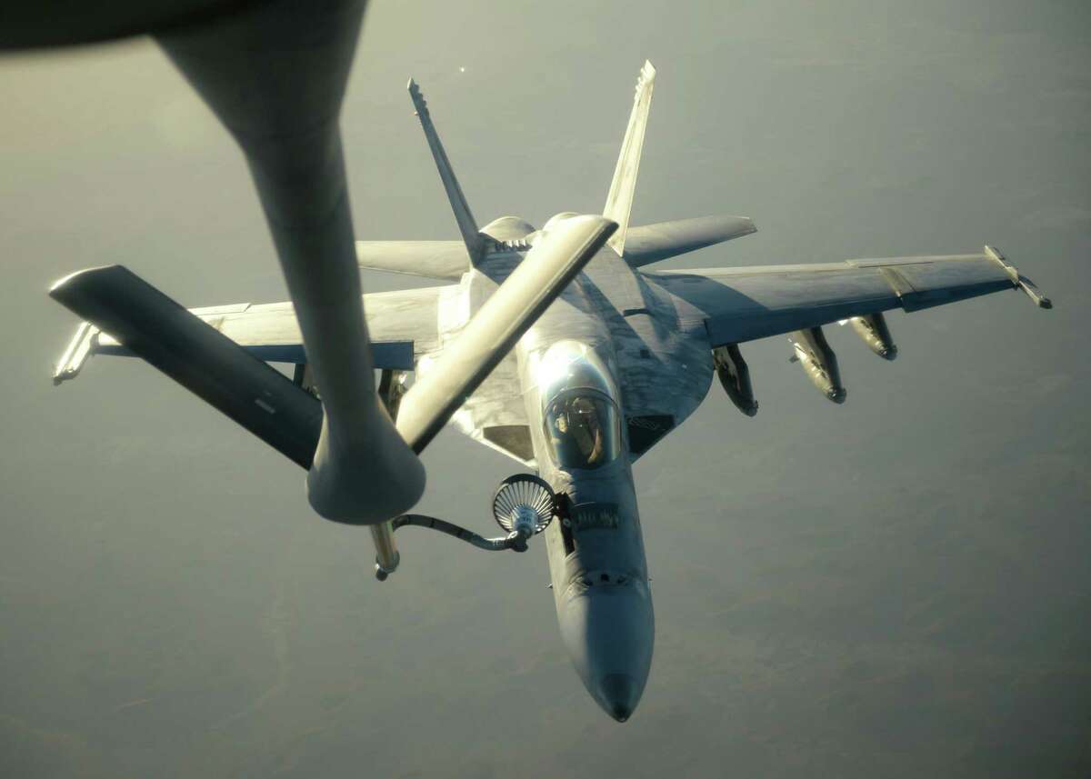 In this Tuesday, Sept. 23, 2014 photo released by the U.S. Air Force, a U.S. Navy F-18E Super Hornet receives fuel from a KC-135 Stratotanker over northern Iraq after conducting airstrikes ias part of U.S. led coalition airstrikes on the Islamic State group and other targets in Syria. U.S.-led airstrikes targeted Syrian oil installations held by the militant Islamic State group overnight and early Thursday, Sept. 25, 2014, killing nearly 20 people as the militants released dozens of detainees in their de facto capital, fearing further raids, activists said. (AP Photo/U.S. Air Force, Staff Sgt. Shawn Nickel)